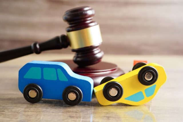 Car accident lawsuit and insurance concept depicted with a judge's gavel and a car model.